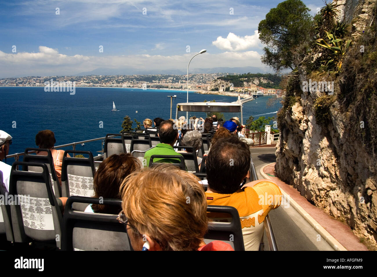 The open topped tourist bus is a good way to see the views around the harbour area of Nice on the Cote d'Azur , French Riviera Stock Photo