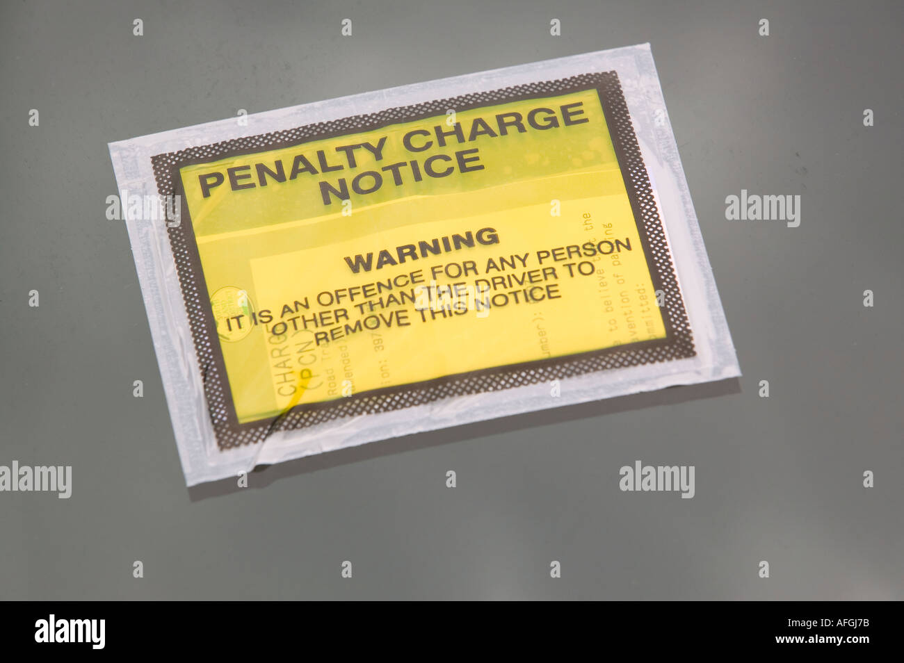 a parking ticket placed on the windscreen of a car parked on double yellow lines Stock Photo