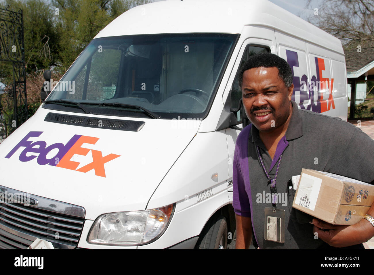 Gainesville Florida,FedEx delivery service van,Black man men male,driver,employee worker workers working staff,box,FL060303078 Stock Photo