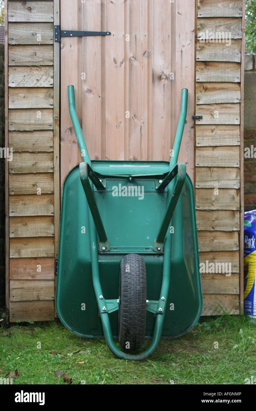 Wheel barrow retsting against shed Stock Photo Alamy