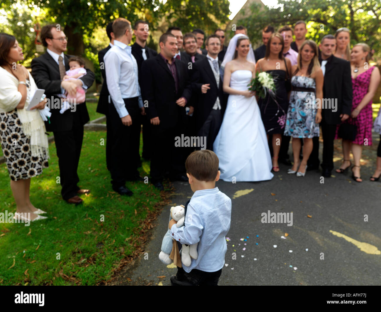 Small Boy Watching Wedding Photographs being Taken Outside St Marys Church Caterham Stock Photo
