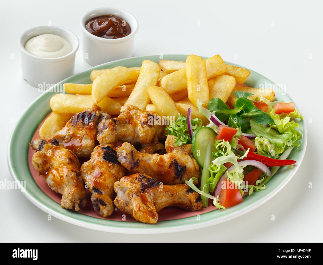 Chicken wings French fries and salad Stock Photo - Alamy