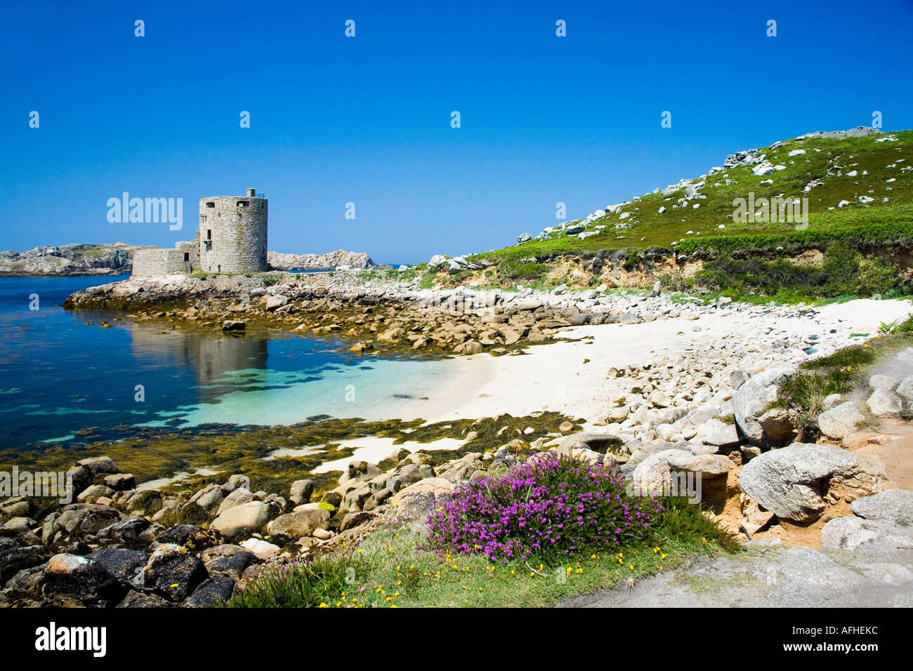 Tresco Cromwell's Castle in summer sun sunshine with sandy beach and blue sky Isles of Scilly Cornwall UK Stock Photo