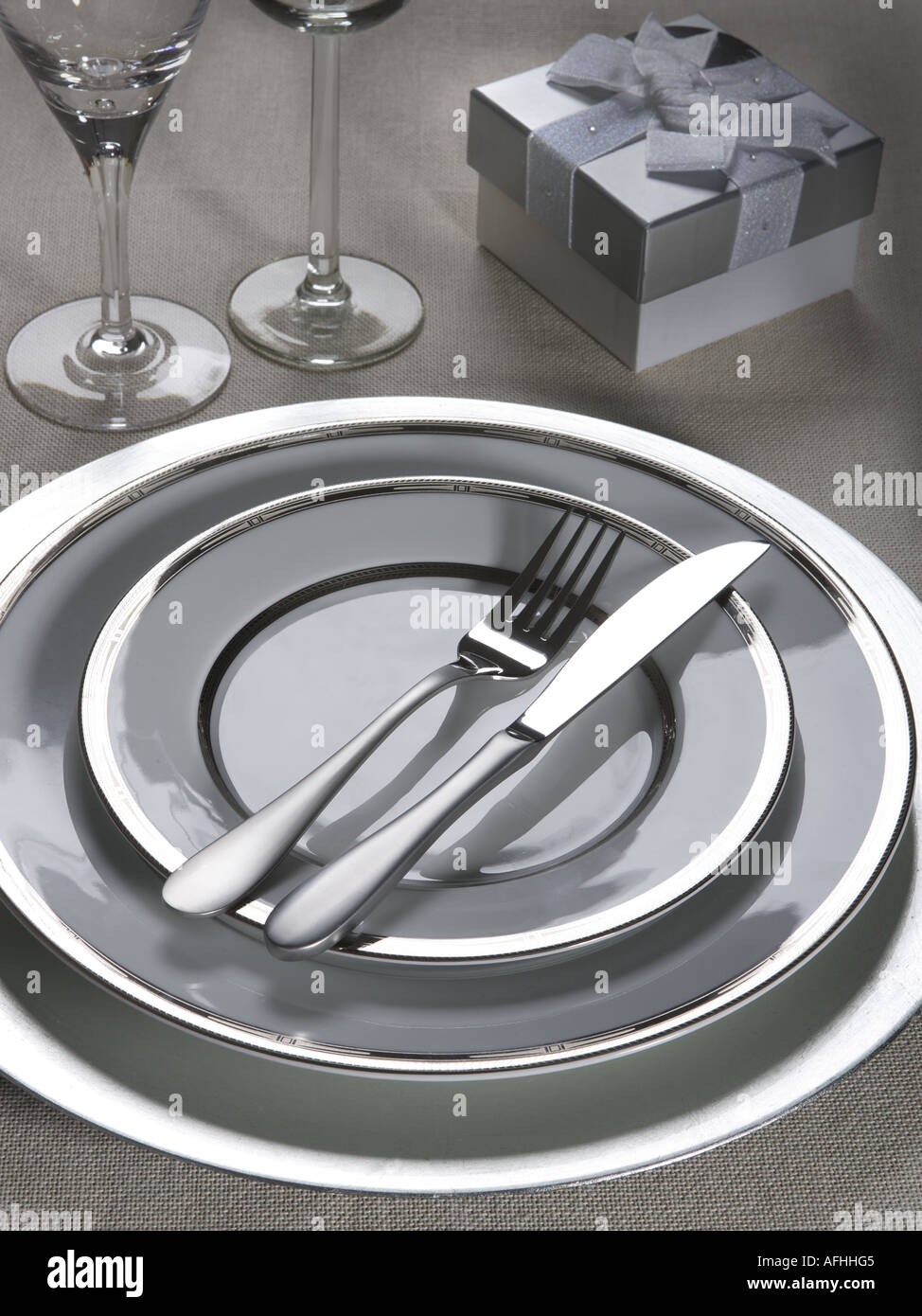 A modern table setting with grey, white and silver edged crockery ... A modern table setting with grey, white and silver edged crockery ...