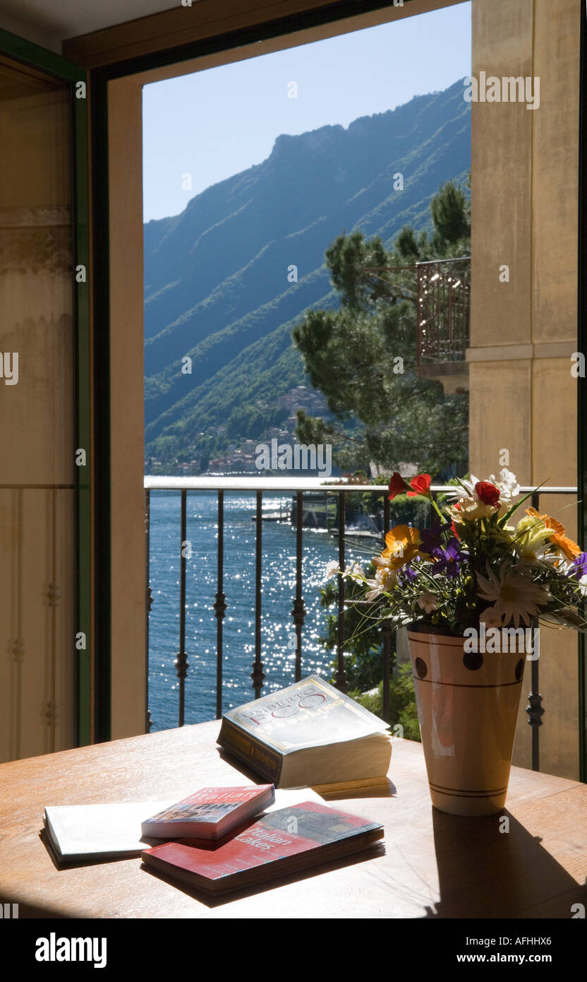 VIEW FROM APARTMENT WINDOW OF SAN MAMETTE VILLAGE AND LAKE LUGANO NORTHERN ITALY WITH BOOKS MAPS Stock Photo