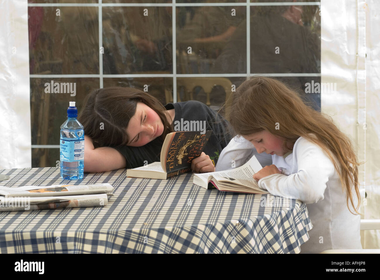 Children reading a book at the Hay on Wye festival of books literature and arts Powys Wales UK 2006 2000s HOMER SYKES Stock Photo