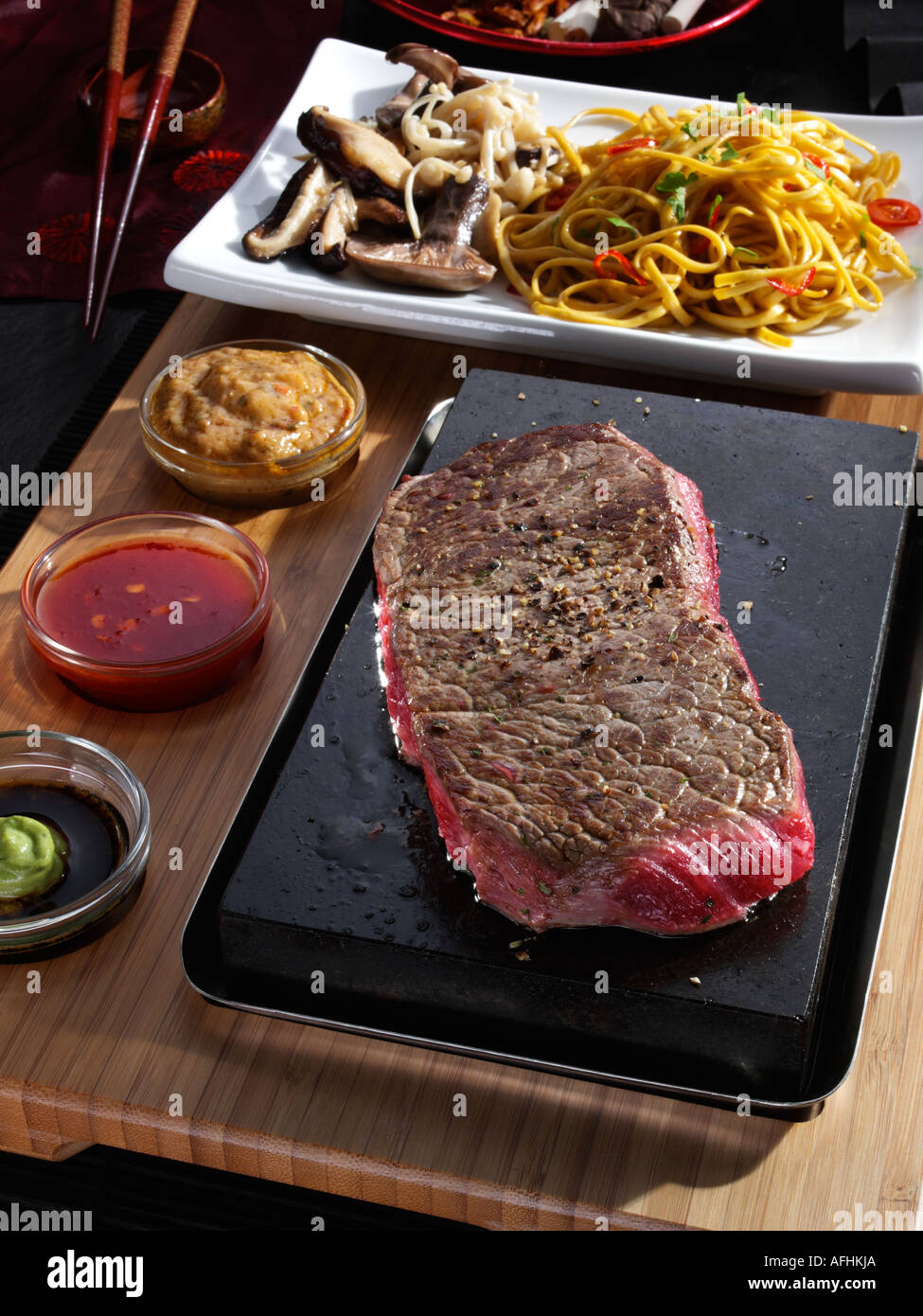 Sizzling stone cooked sirloin steak mushrooms pasta hires stock