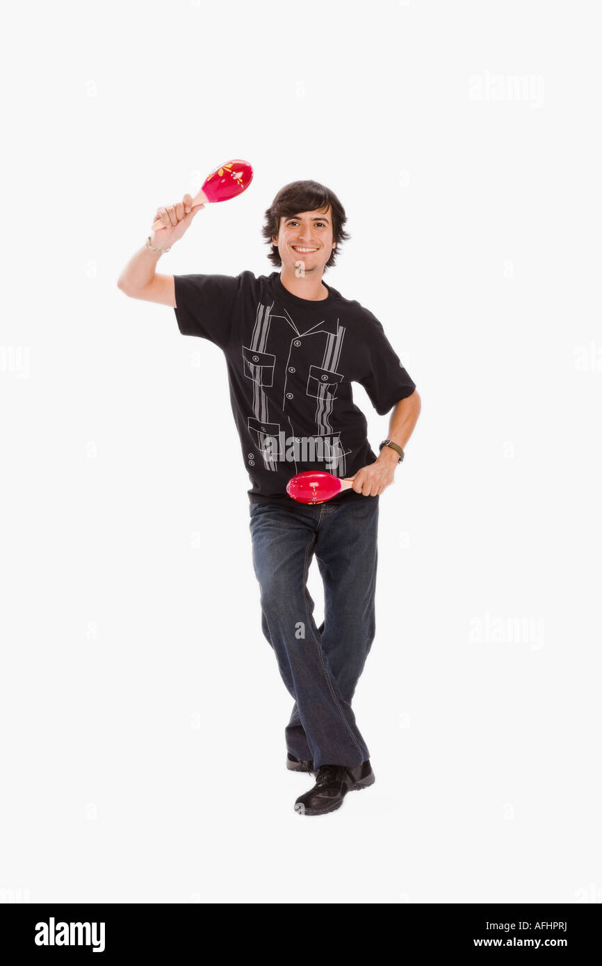 Studio portrait of young man dancing with maracas Stock Photo Alamy
