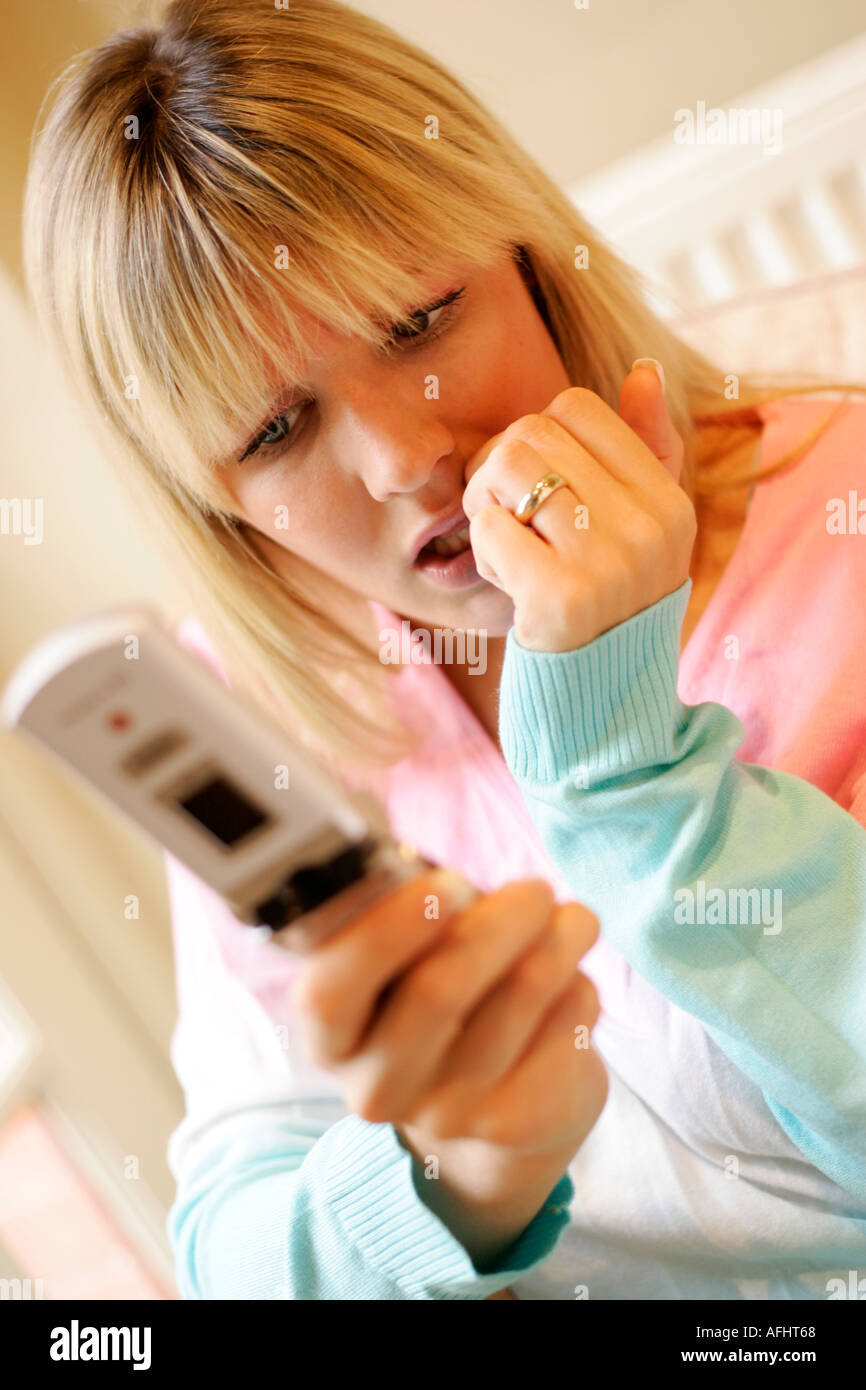 woman looking worried by mobile phone message Stock Photo
