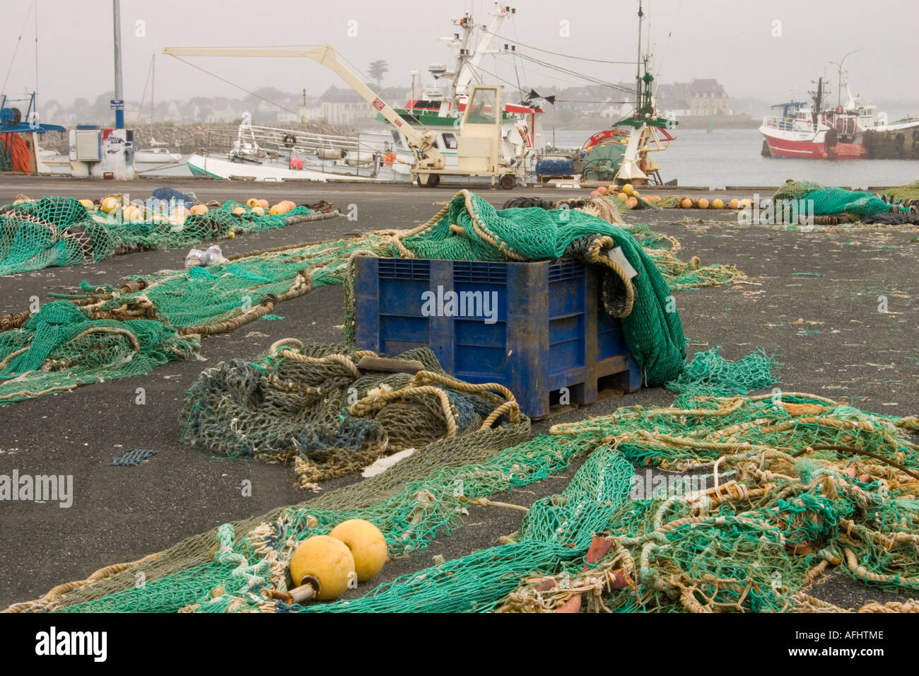 https://c8.alamy.com/comp/AFHTME/fishing-nets-laid-out-on-quayside-in-loctudy-brittany-france-with-AFHTME.jpg