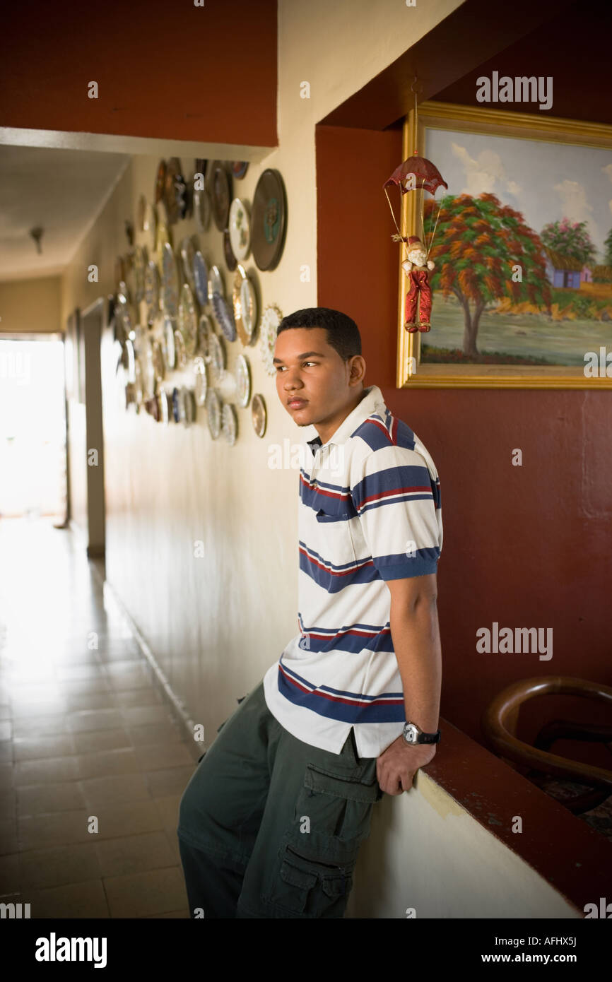 Young man leaning against a wall and looking away Stock Photo - Alamy