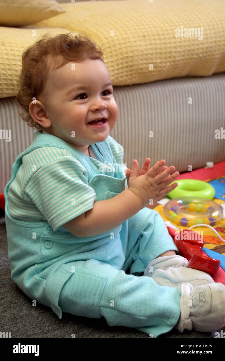 one year old sitting up playing pat a cake Stock Photo Alamy