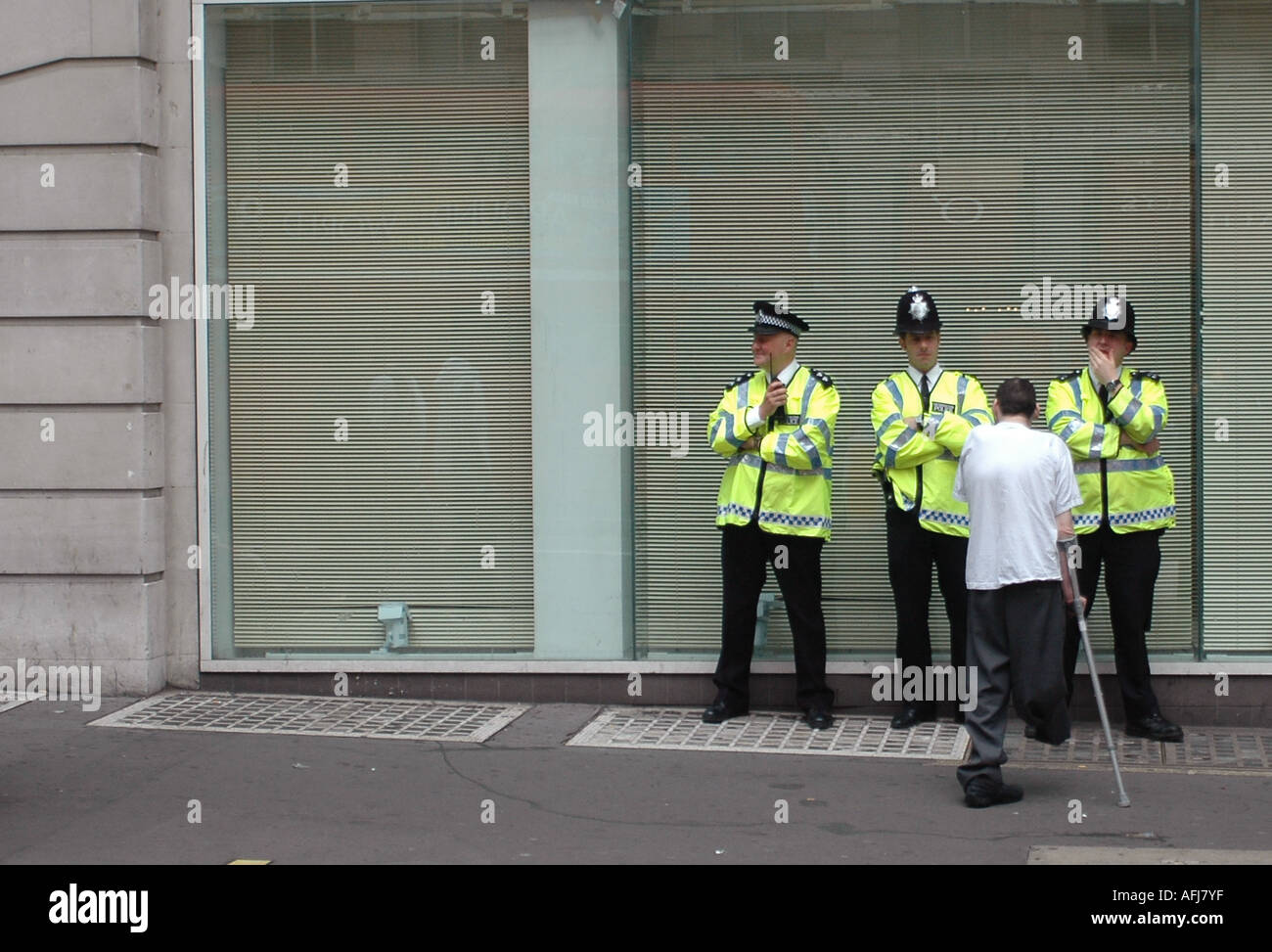 Disabled man talking to three policemen in the streets of  London Stock Photo