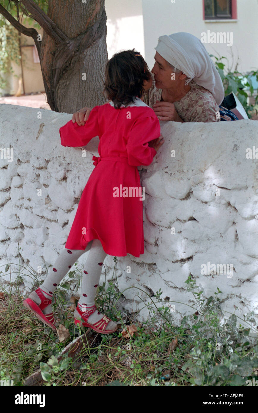 Young Turkish school girl greeting her grandmother in small village in South Western Turkey. Stock Photo