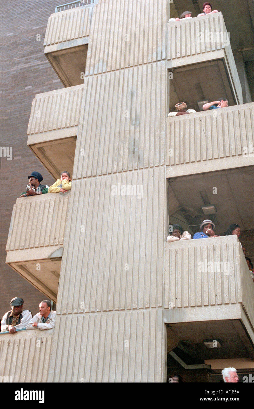 Residents in West London housing estate on their balconies watching Nottinghill carnival going by. Stock Photo