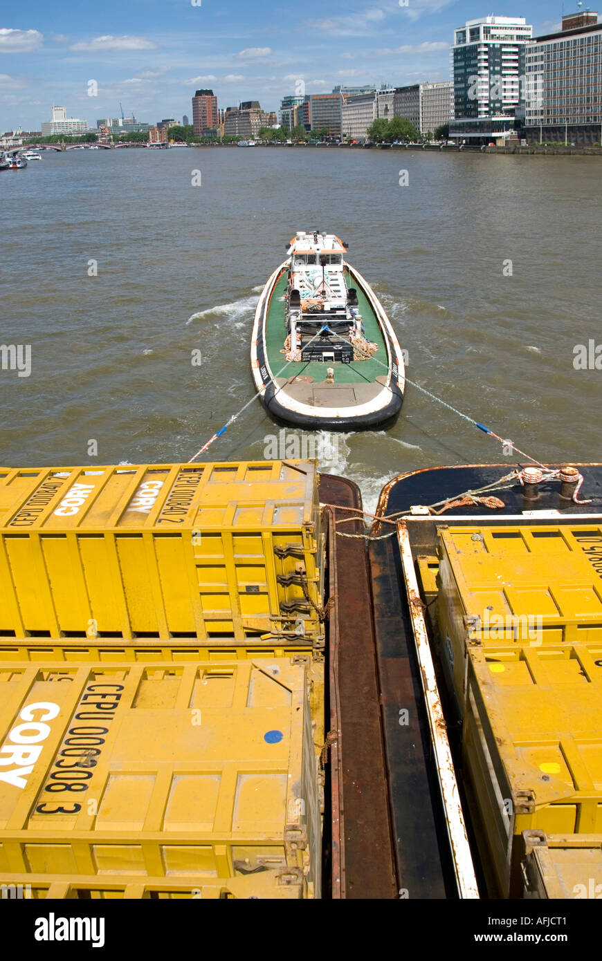 River Thames and Cory waste management company tug towing barges down river loaded with containers full of refuse Stock Photo
