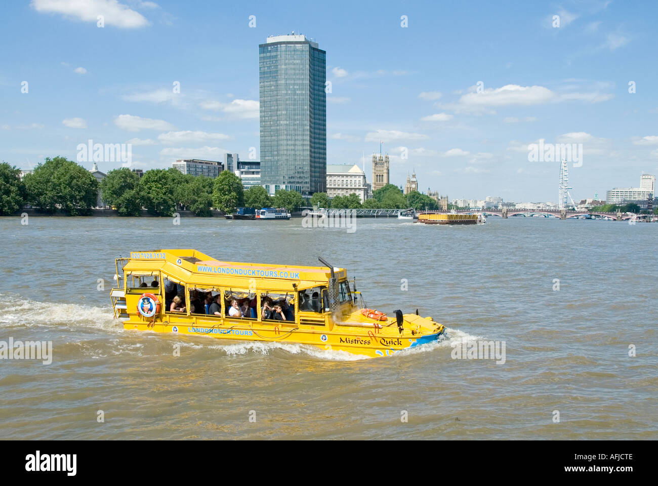 Group of people amphibious transport sightseeing tour boat for tourist travel on River Thames Millbank skyscraper landmark London tourism England UK Stock Photo