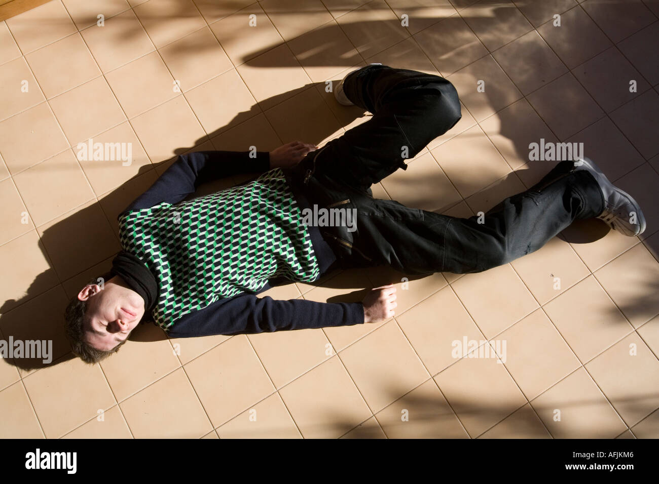 Young boy playing dead on the floor Stock Photo