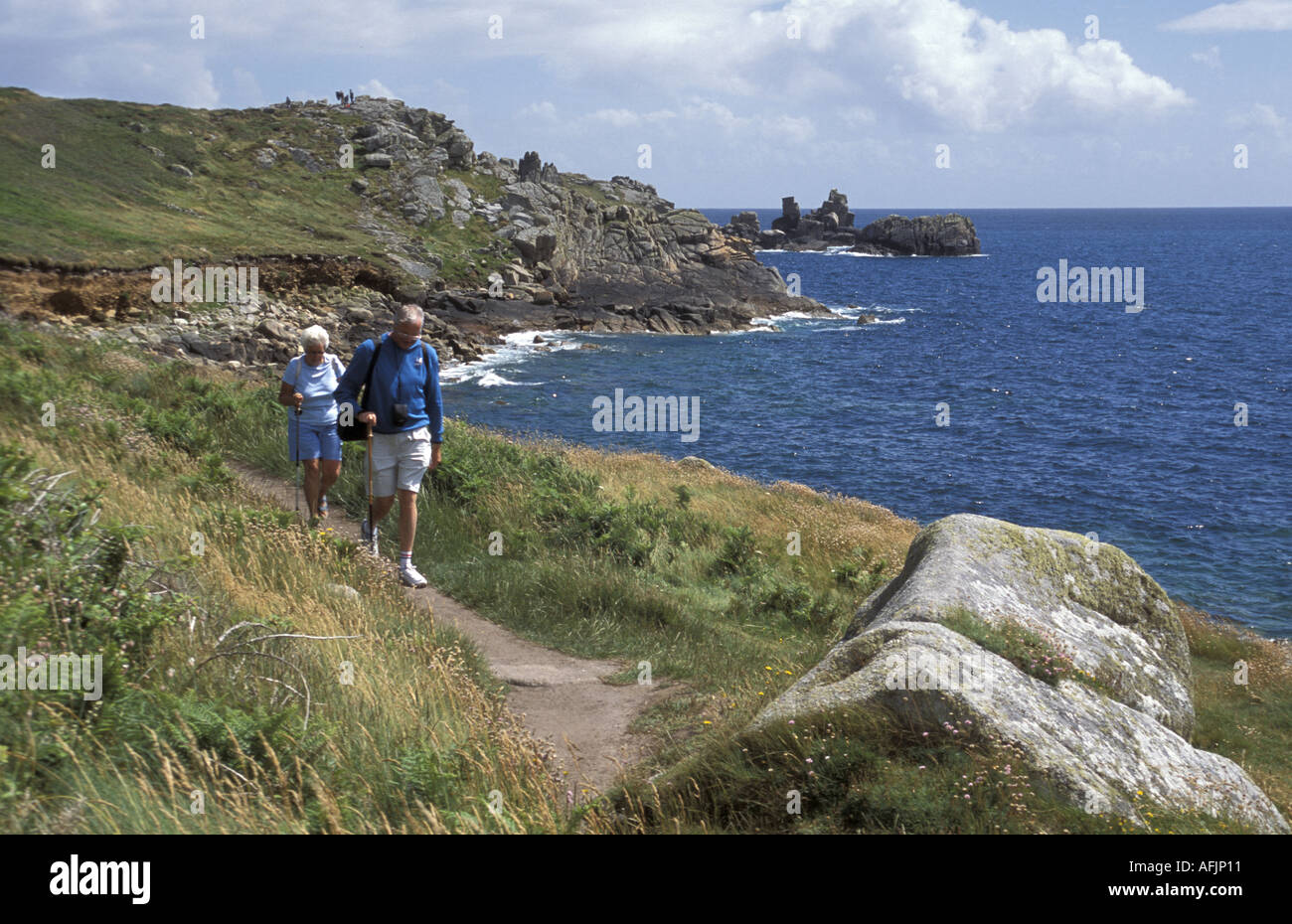 Walkers on Peninnis Head St Mary s Isles of Scilly Cornwall England Stock Photo