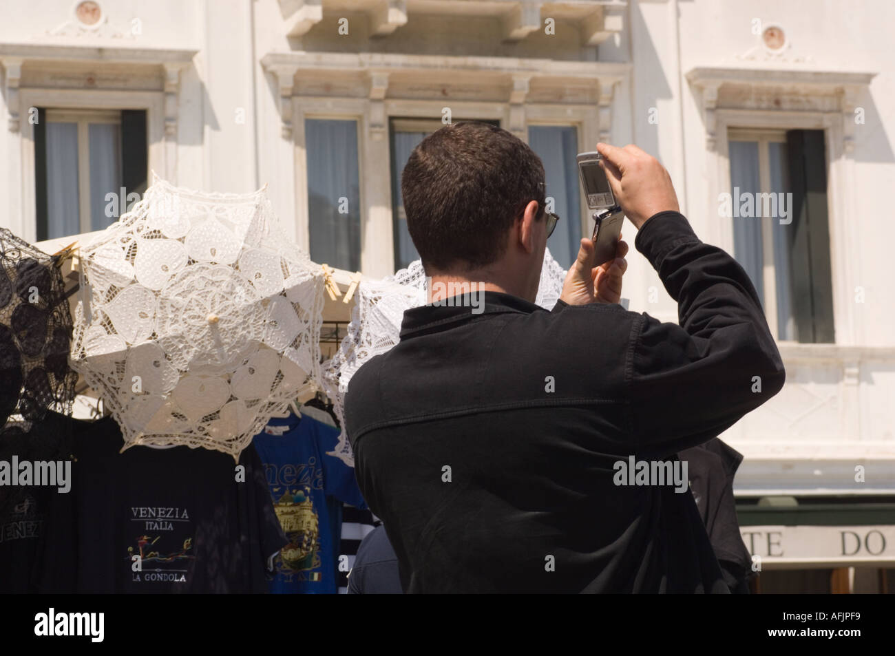 young man with a cell phone camera photographing the Londar Palace Hotel along the Riva Degli Schiavoni waterfront in Venice Stock Photo