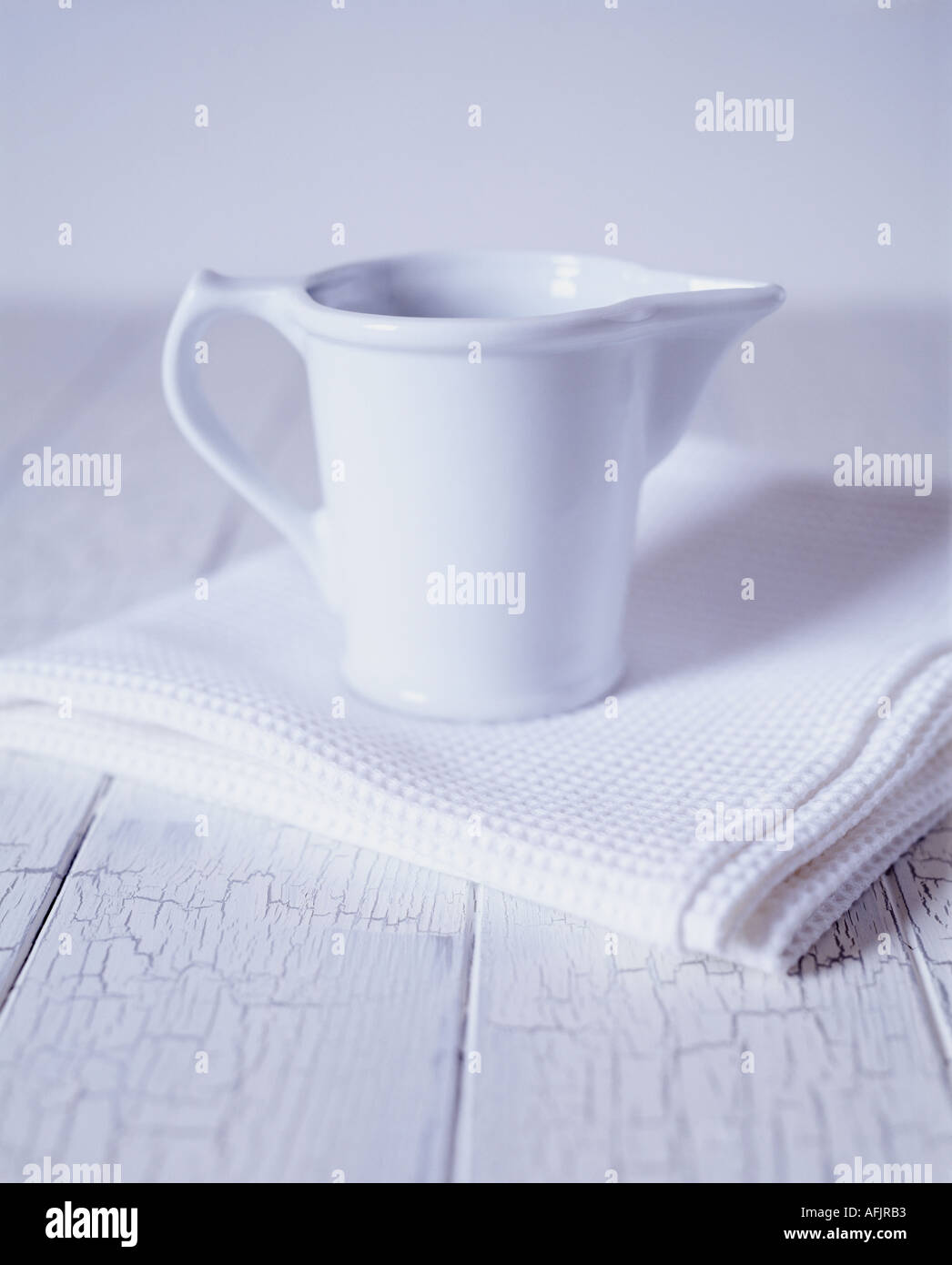 White jug and white towel on white crackleglazed wood Stock Photo