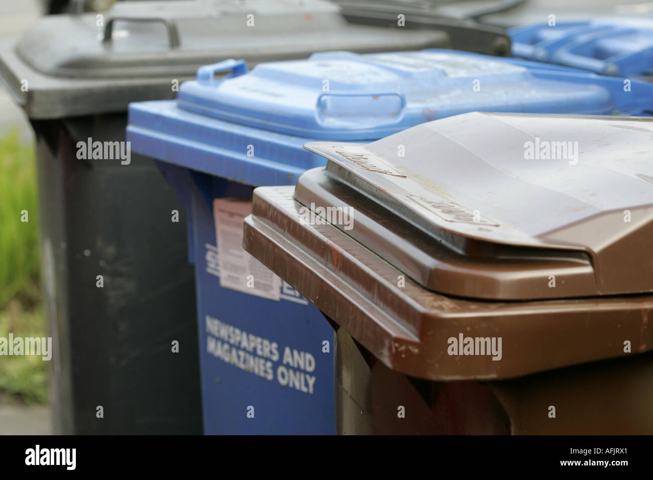 A selection of waste bins including refuse paper recycling blue and garden waste recycling bin brown for a household Stock Photo