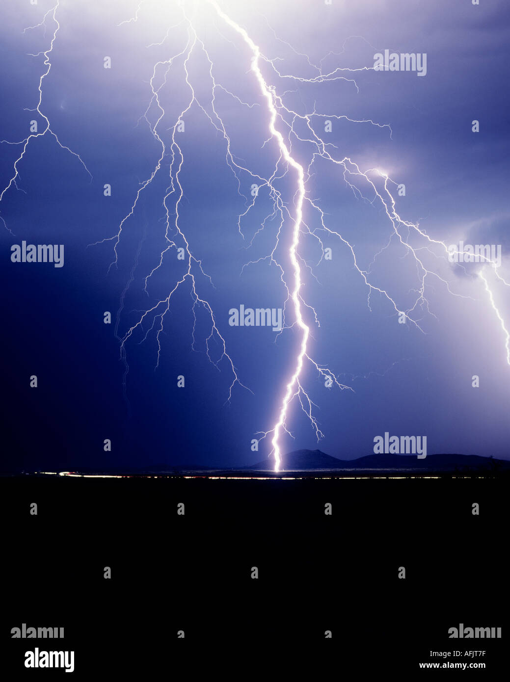 Cropped shot of a huge singular lightning bolt striking against a dark blue sky outside of Tucson, Arizona, USA Stock Photo