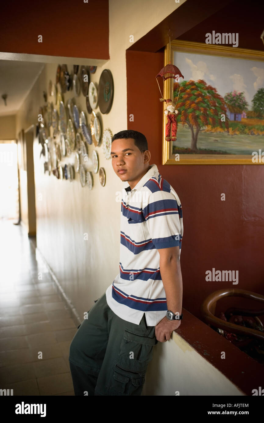 Young man leaning against a wall and thinking Stock Photo - Alamy