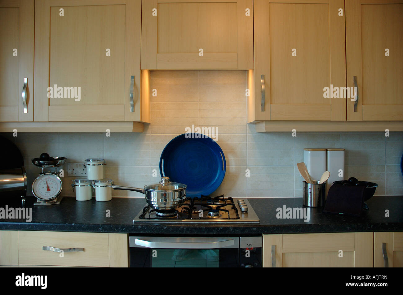 Close up of light wood cupboards and gas hob in modern kitchen Stock