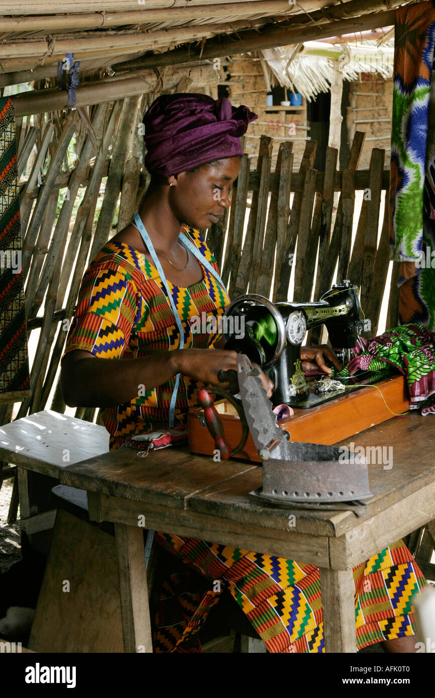 Ghanaian woman seamstress using hand operated sewing machine West