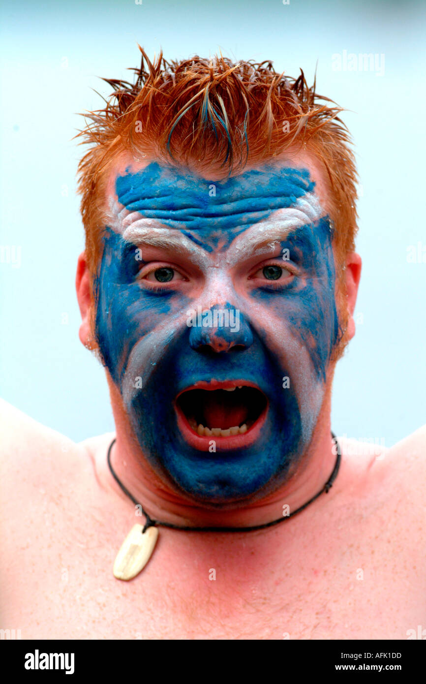 A Scotsman wearing the Scottish flag colours painted onto his face Scotland United Kingdom Stock Photo