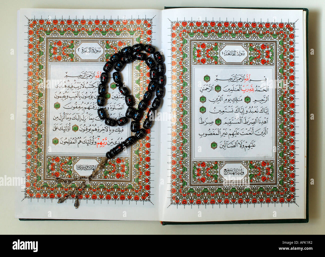 A copy of the sacred text of Islam Qur'an opened for reading with prayer beads called Tasbeeh Stock Photo