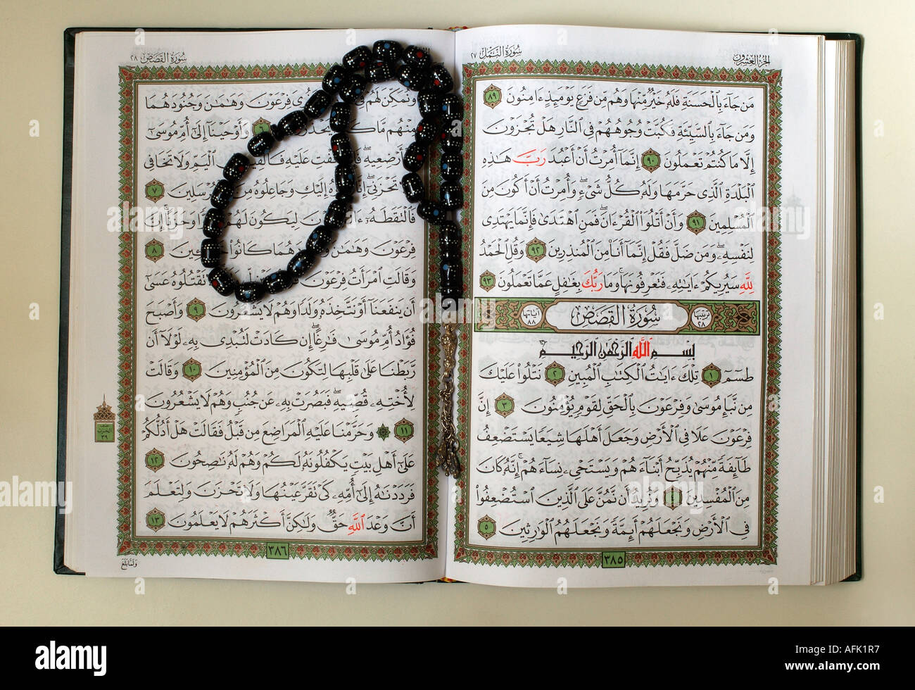 An open copy of the sacred text of islam qur an with prayer beads