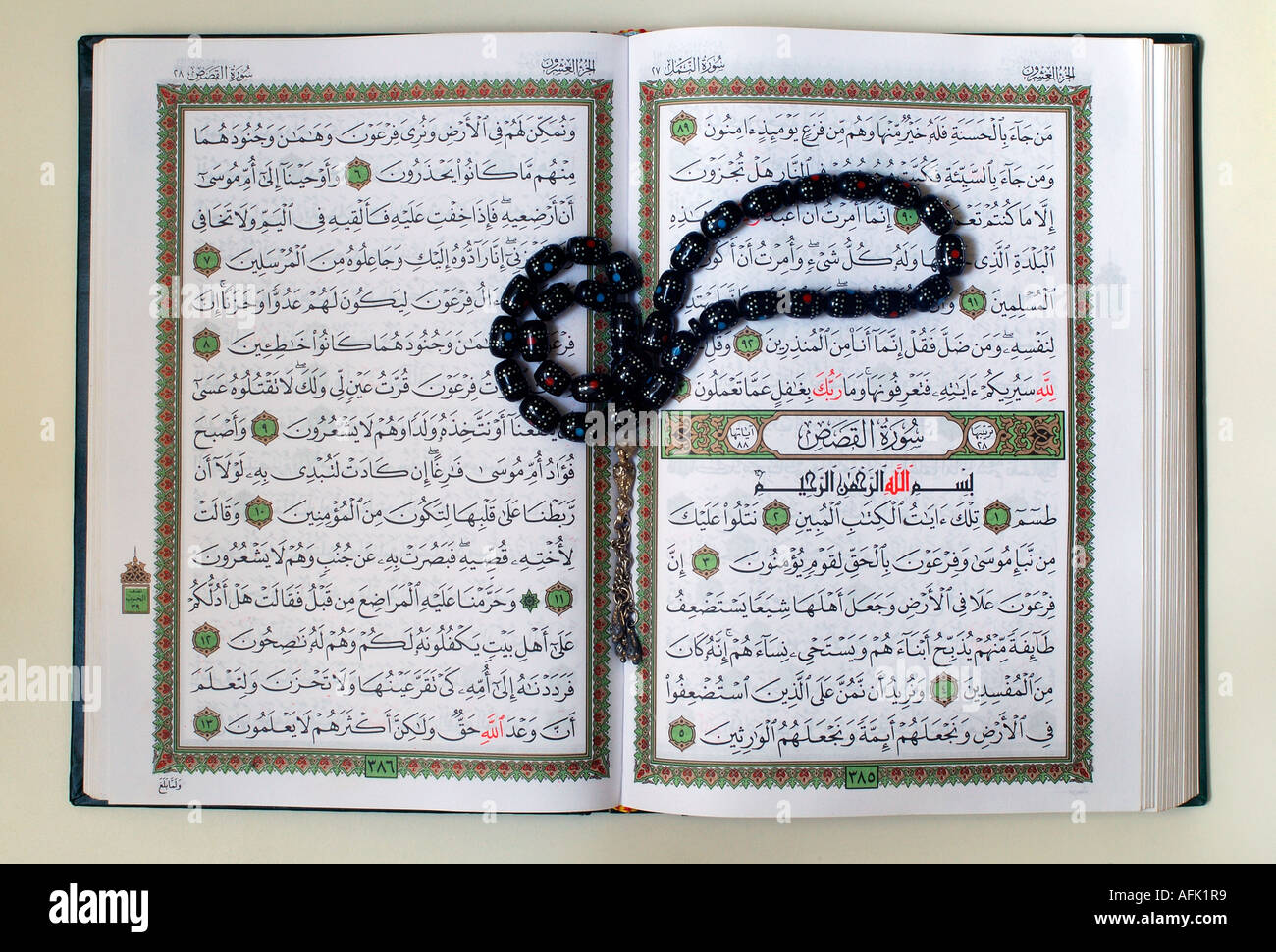 An open copy of the sacred text of islam qur an with prayer beads