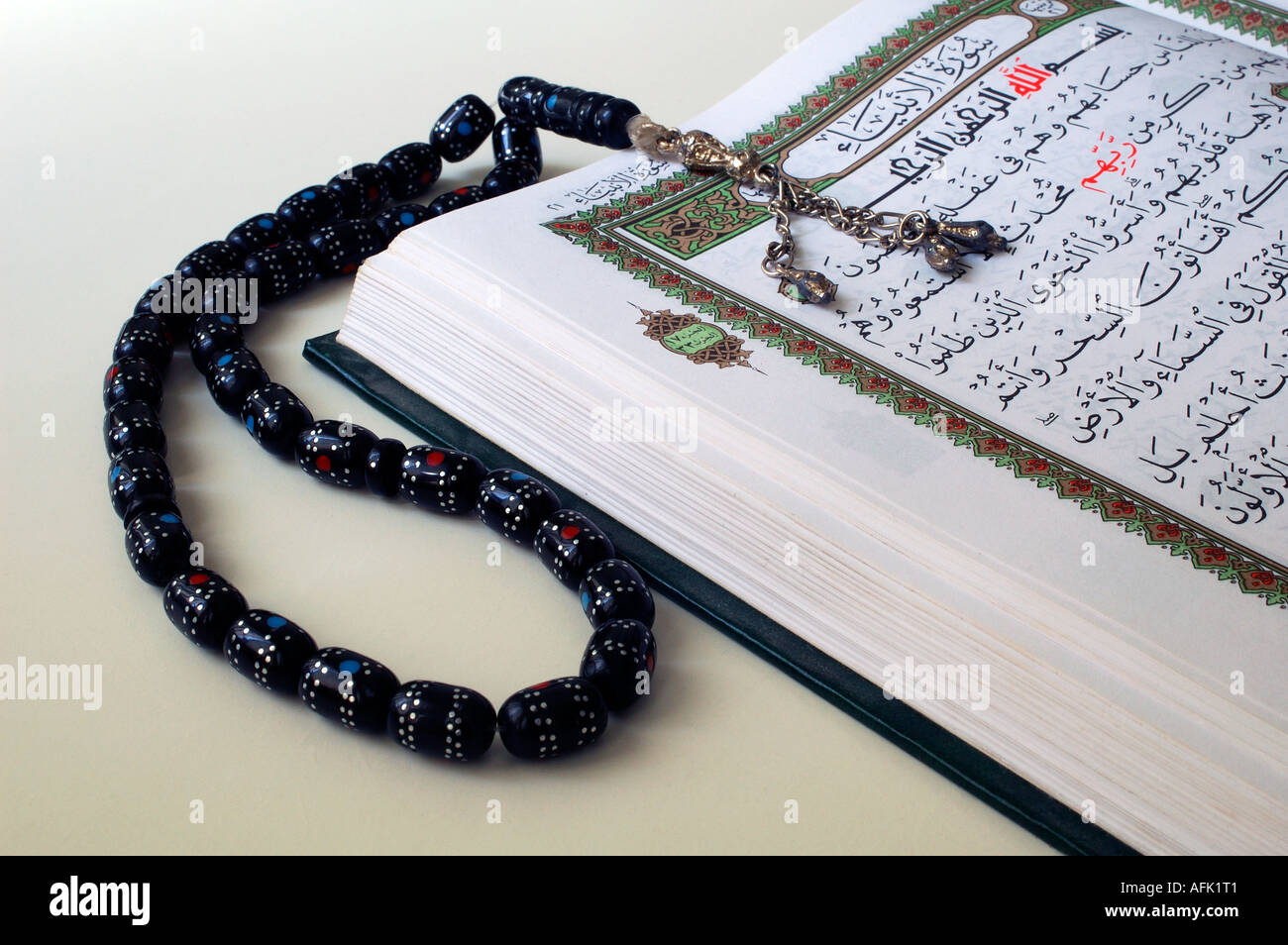 An open copy of the sacred text of islam qur an with prayer beads