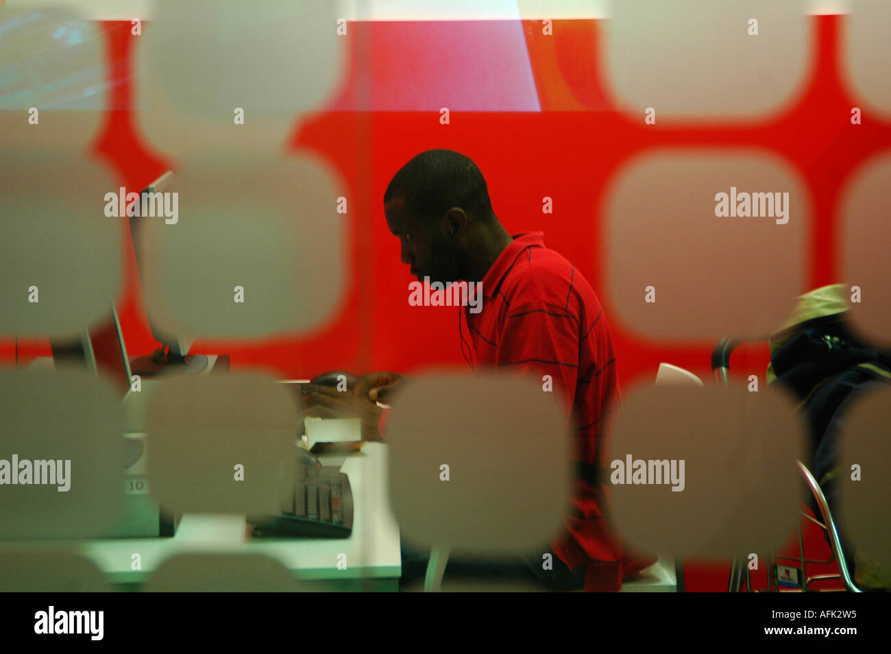 Black person working on computer seen through decorated glass window Stock Photo