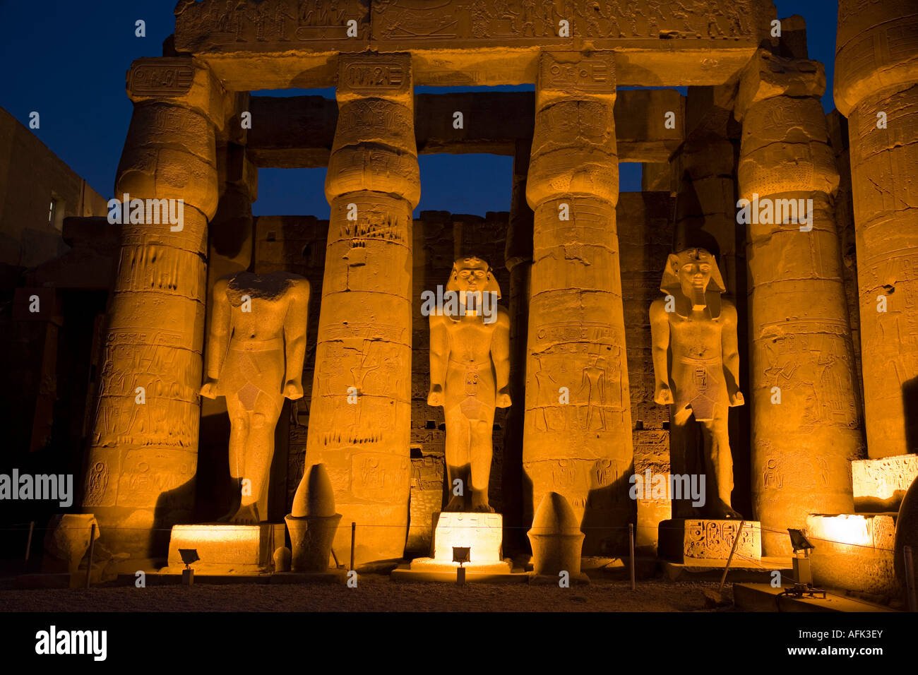 Larger than life statues of Ramses II illuminated at night in Luxor ...