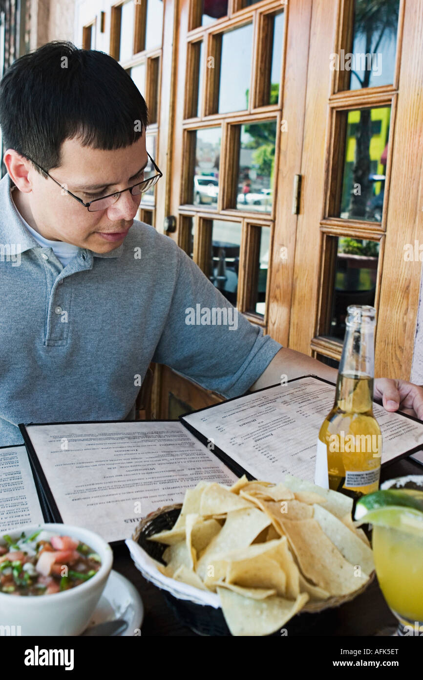 Man reading menu at outdoor restaurant. Stock Photo