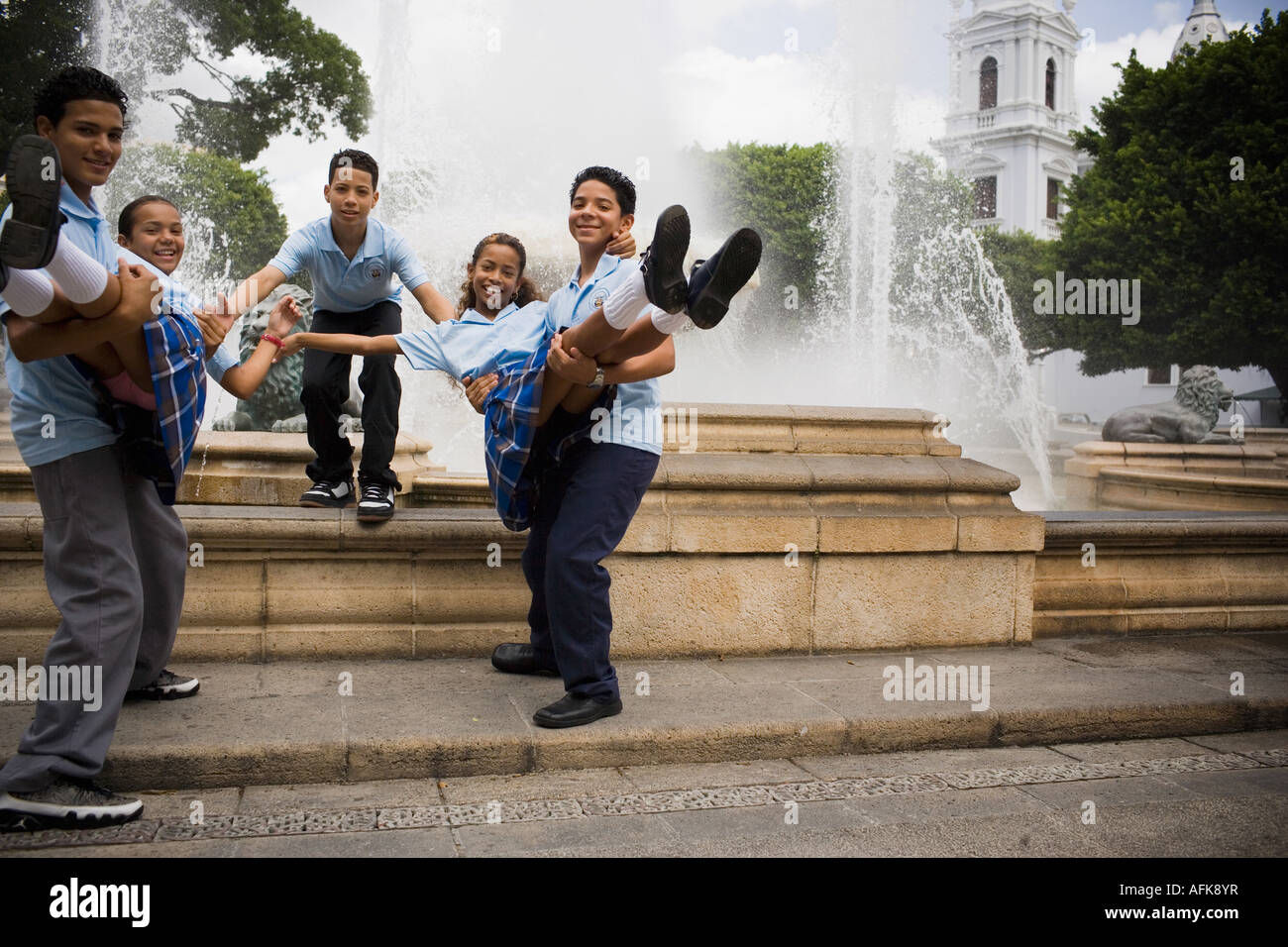 School boys carrying girls in center plaza Stock Photo Alamy