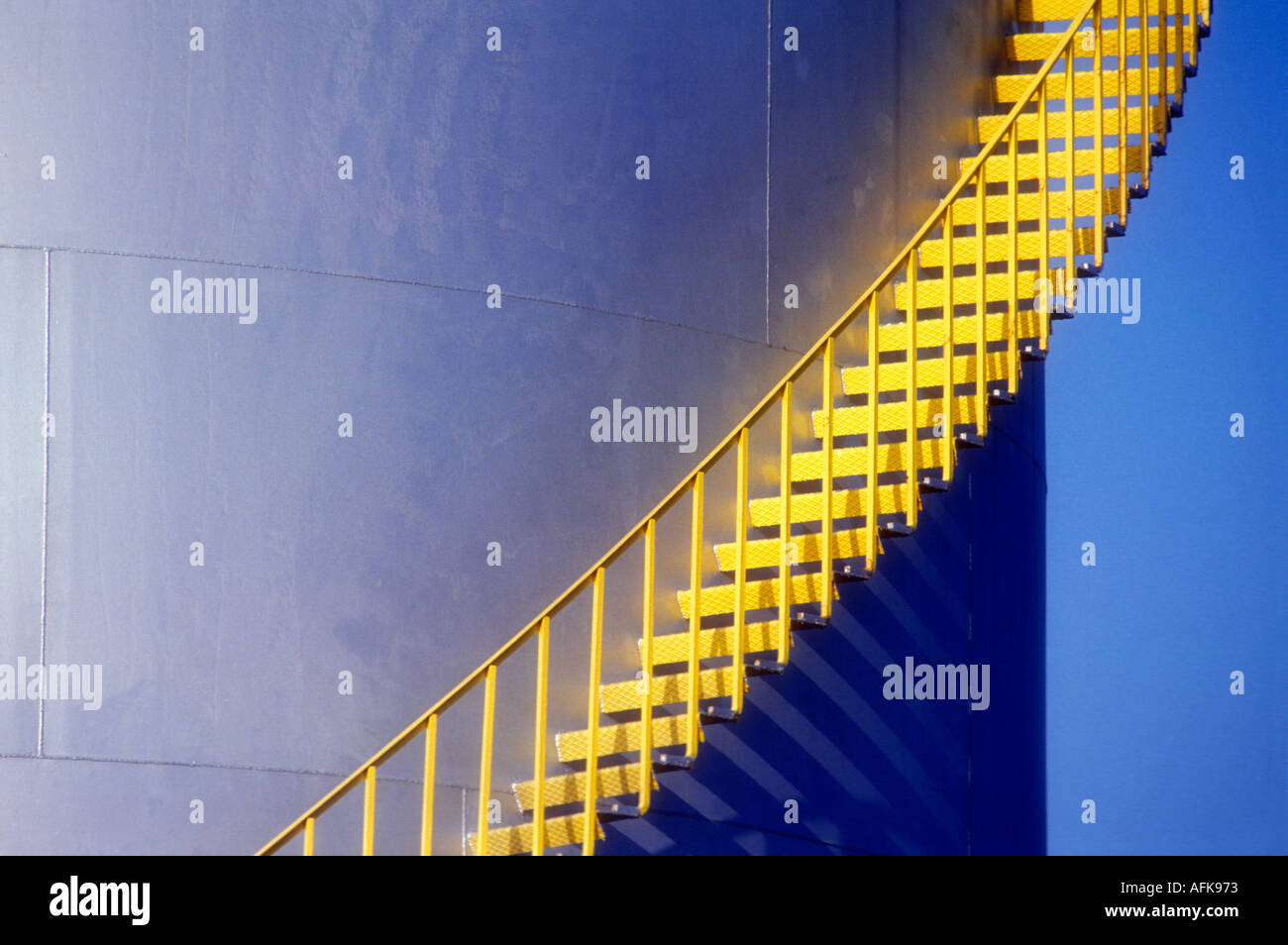 Yellow stairs on side of large petroleum storage tank Stock Photo