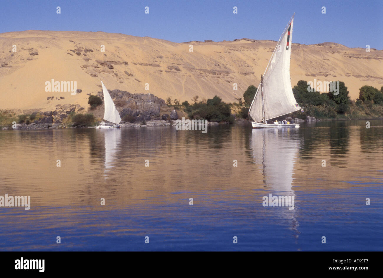 Two feluccas sailing towards each other on the River Nile near Aswan Egypt Stock Photo