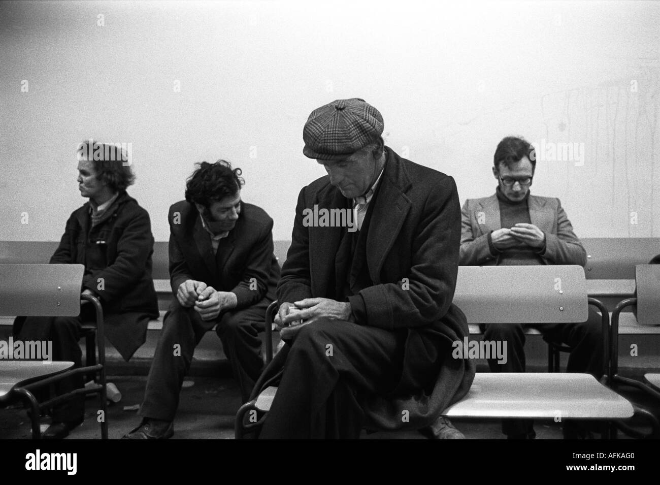 Unemployed men 1970s signing on weekly to collect their unemployment payment. On the Dole, Labour Exchange Elephant and Castle, London office1976. Stock Photo