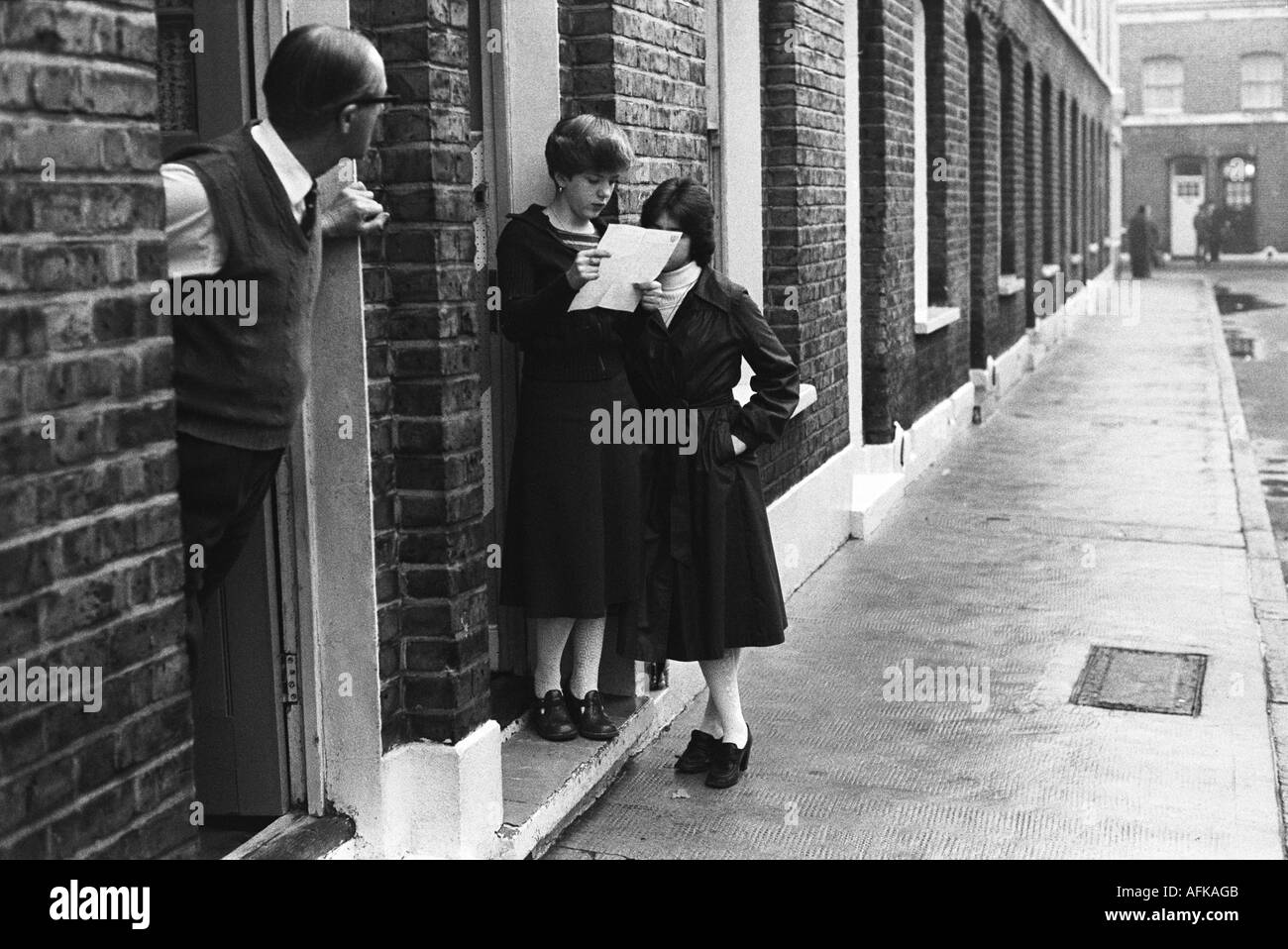 1970s Elephant and Castle London, girls reading a letter on the door step of their terraced home. working class neighbourhood street scene 1970 UK Stock Photo