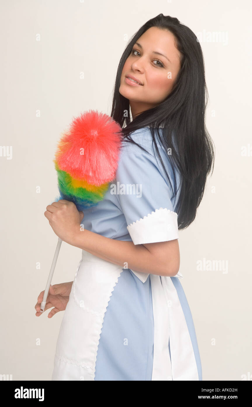 Maid holding feather duster Stock Photo Alamy