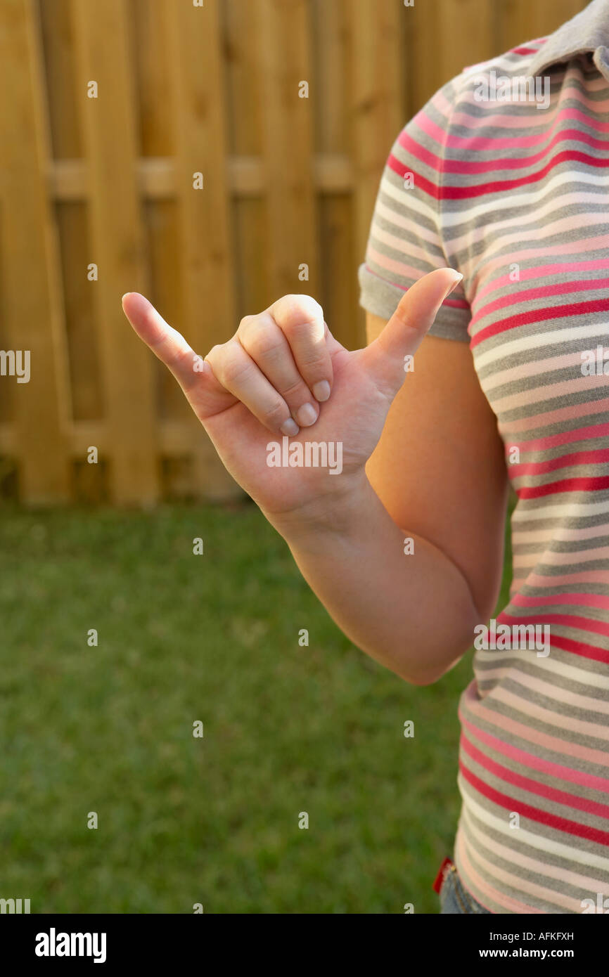 Mid section view of a woman making a shaka sign Stock Photo
