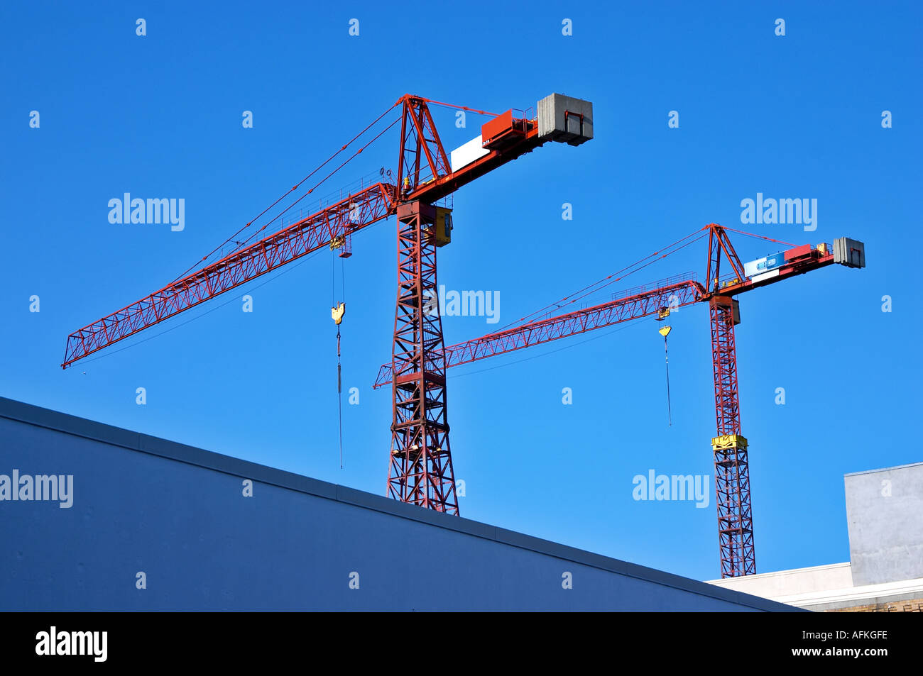 2 construction cranes against deep blue sky Stock Photo