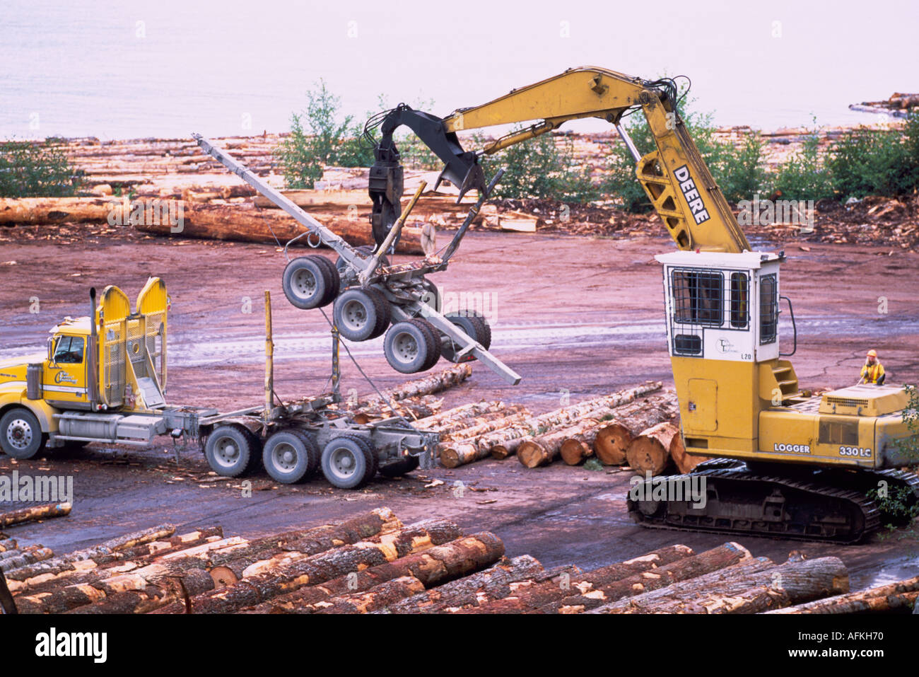 A Log Picker stacking the Trailer on a Logging Truck at a Log Yard at