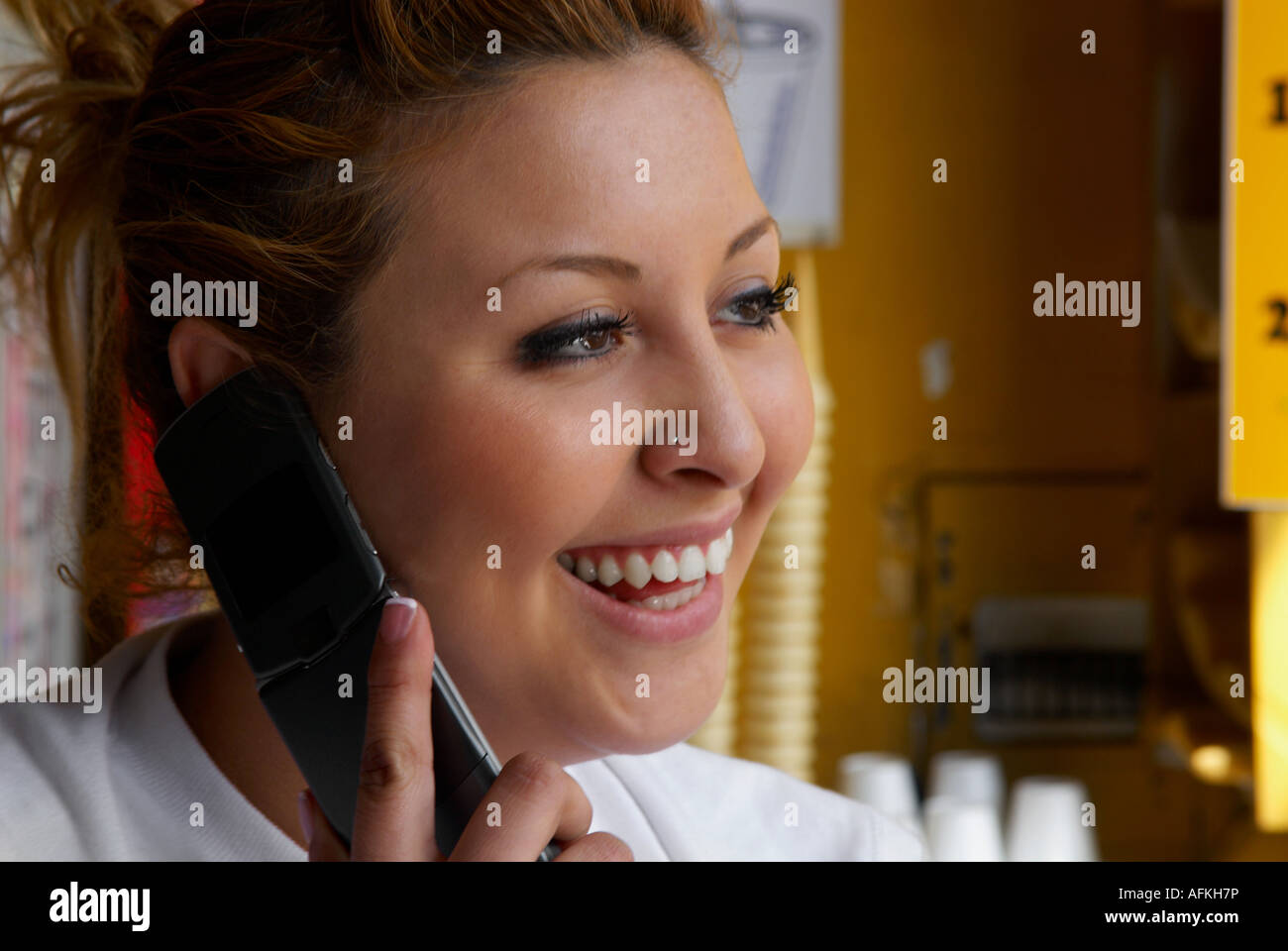Closeup of a female icecream shop owner talking on a mobile phone