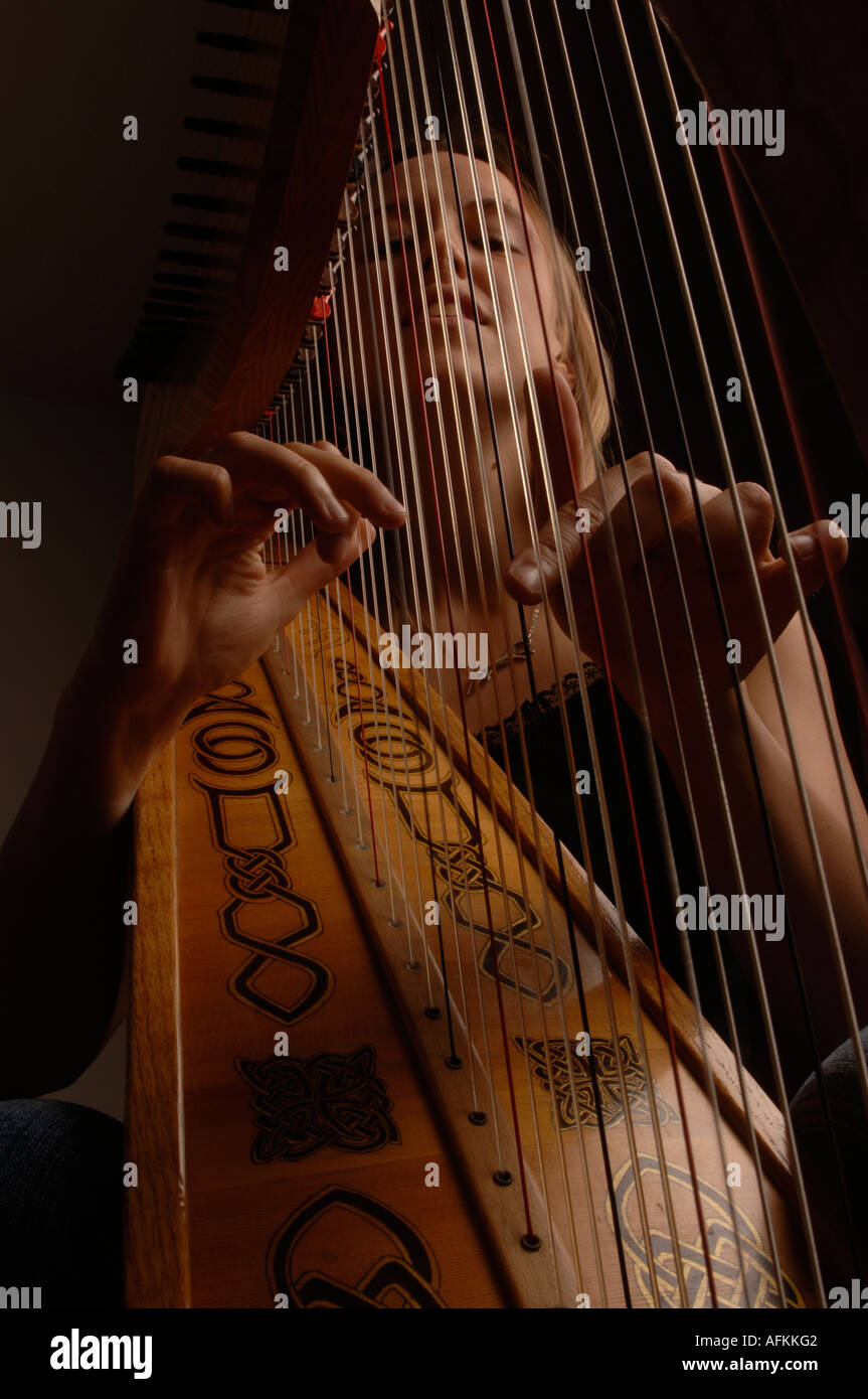 welsh folk music smiling woman and harp in studio (Harriet Earis Stock