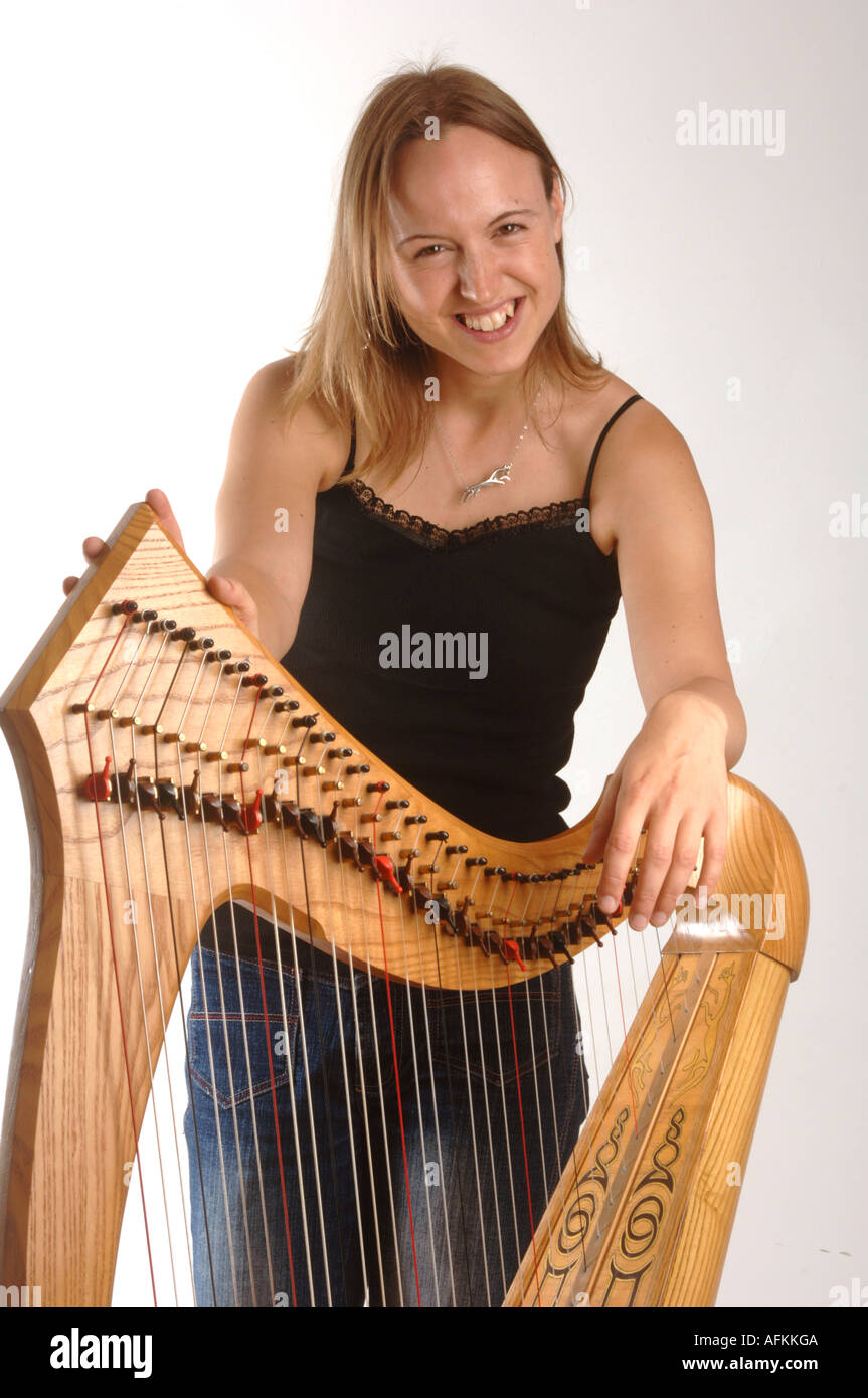welsh folk musician Harriet Earis,  smiling young attractive woman and traditional harp in studio Stock Photo